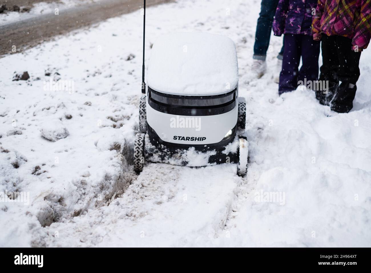 Tallinn, Estland - 4. Dezember 2021: Raumschiff Technologies autonomes Drohnenfahrzeug im Winter im Schnee stecken geblieben. Selbstfahrende kontaktlose Zustellroboter. Stockfoto