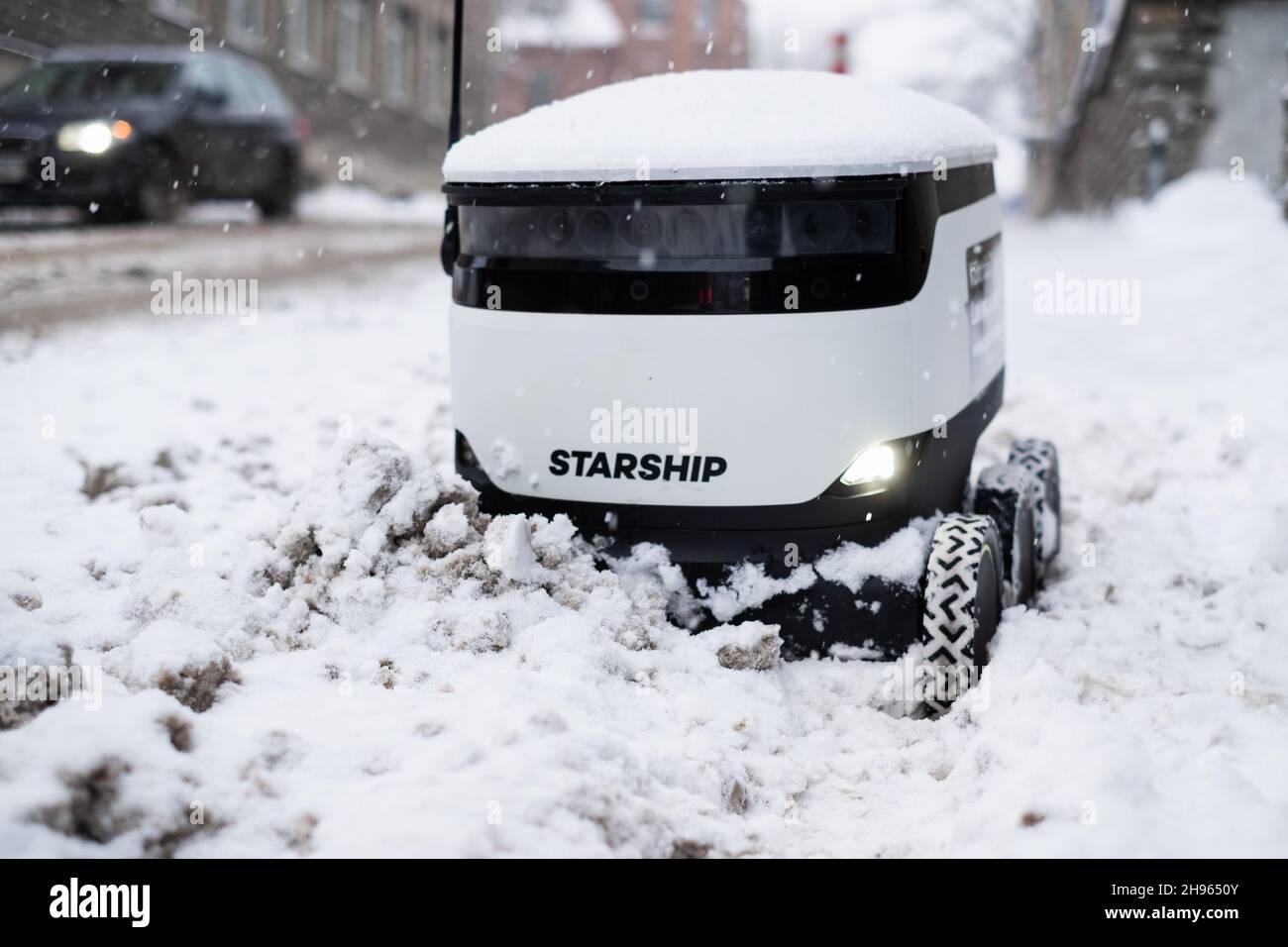 Tallinn, Estland - 4. Dezember 2021: Raumschiff Technologies autonomes Drohnenfahrzeug im Winter im Schnee stecken geblieben. Selbstfahrende kontaktlose Zustellroboter. Stockfoto