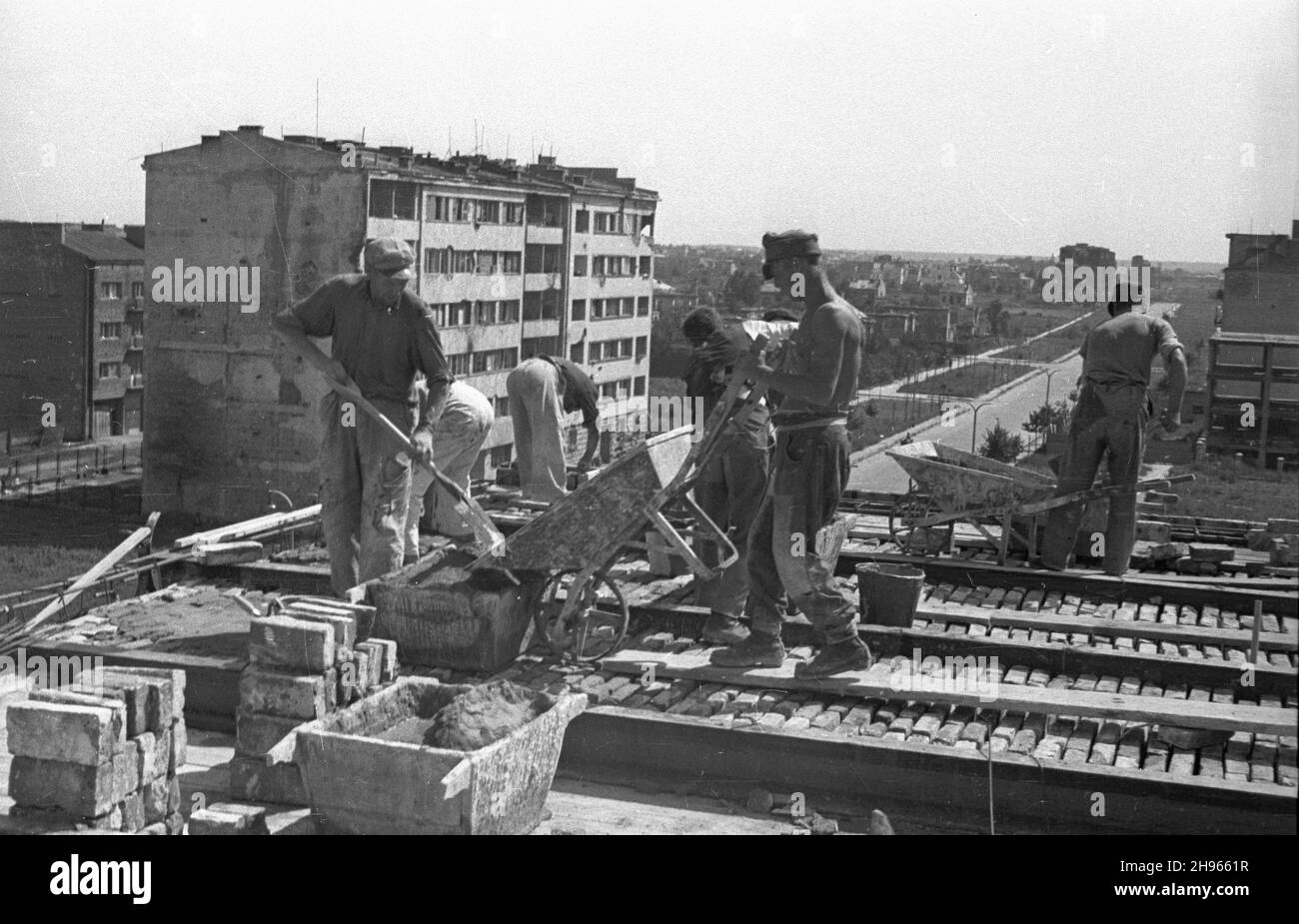 Warszawa, 1947-08. Budowa bloku kolonii mieszkaniowej Ministerstwa Bezpieczeñstwa Publicznego przy skrzy¿owaniu alei Niepodleg³oœci i ulicy Madaliñskiego. NZ. Robotnicy buduj¹cy Strop. W tle aleja Niepodleg³oœci, widok w kierunku Wierzbna. wb/gr PAP Dok³adny dzieñ wydarzenia nieustalony. Warschau, 1947. August. Bau eines Blocks der Wohnanlage des öffentlichen Sicherheitsministeriums an der Kreuzung der Straßen Niepodleglosci und Madalinskiego. Im Bild: Deckengebäude. Im Hintergrund Niepodleglosci Avenue. wb/gr Stockfoto