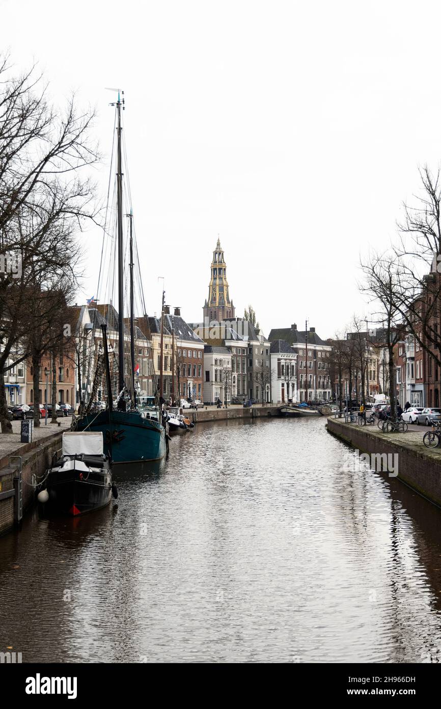 Ein wolkiger Novembertag entlang des Kanals bei Hoge der A in Groningen, Niederlande. Die AA-Kerk befindet sich in der Ferne. Stockfoto