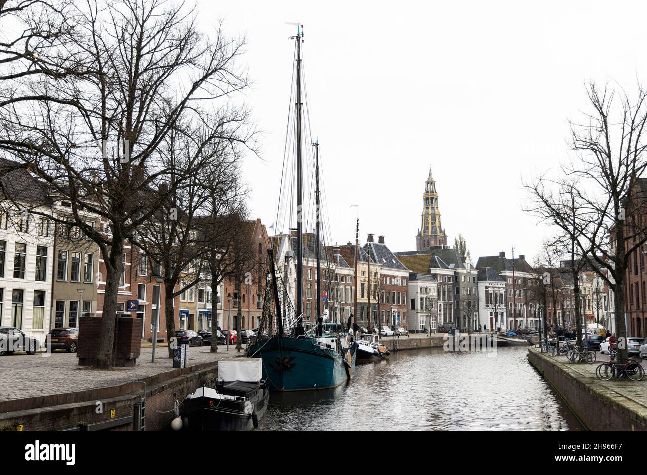 Ein wolkiger Novembertag entlang des Kanals bei Hoge der A in Groningen, Niederlande. Die AA-Kerk befindet sich in der Ferne. Stockfoto