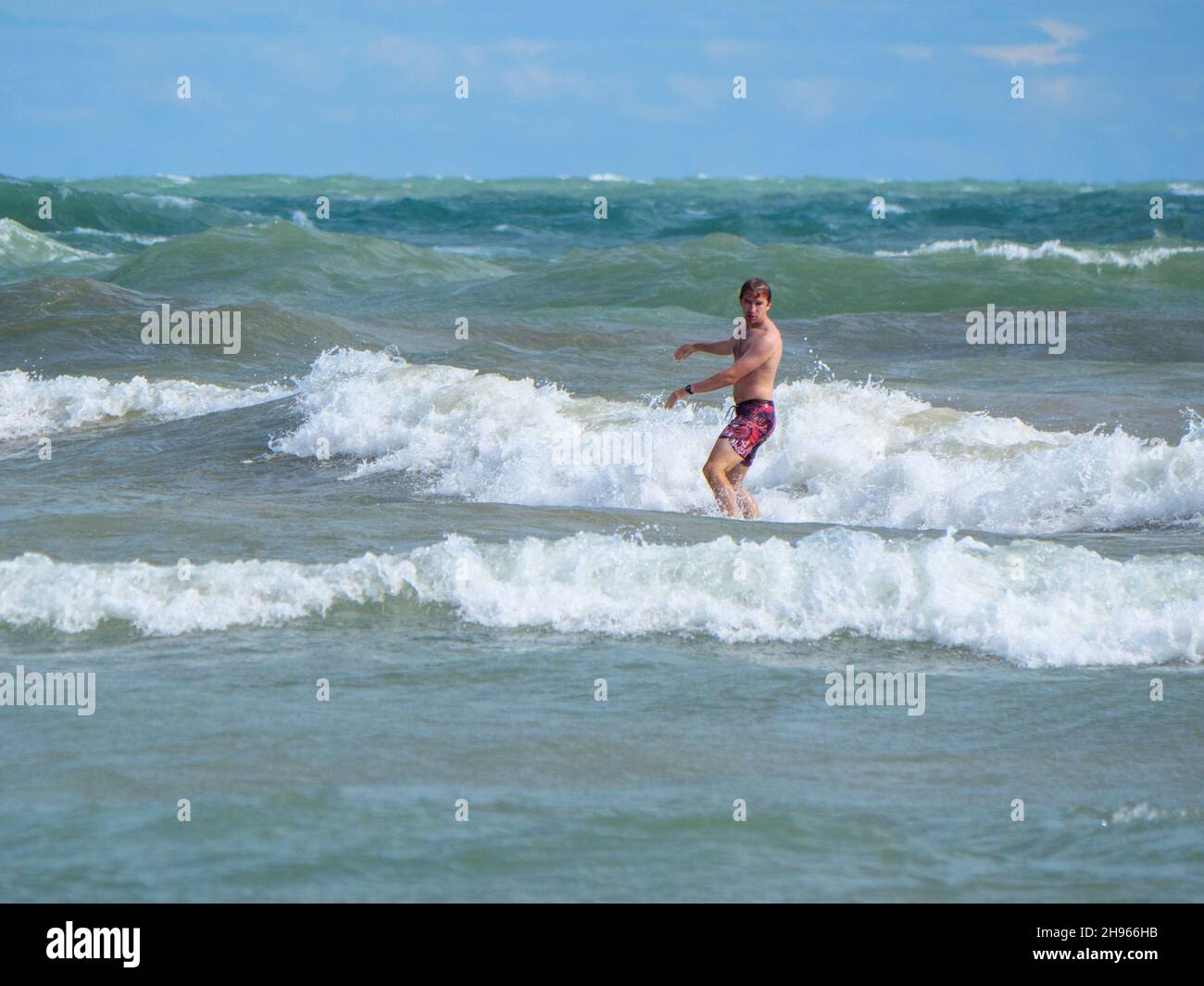 Ein Surfer fängt eine Welle am Chicagoer Montrose Beach ein. Stockfoto
