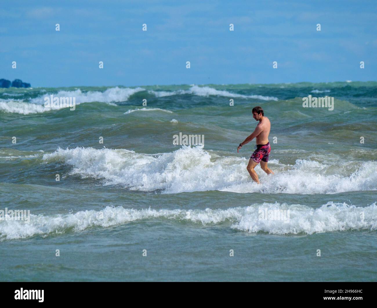 Ein Surfer fängt eine Welle am Chicagoer Montrose Beach ein. Stockfoto