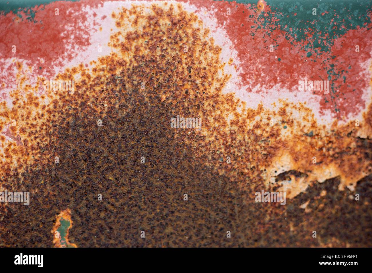 Lackierte Eisenoberfläche mit sich verschlechternder Oberfläche, auf der Rost durch die Farbe kommt. Stockfoto