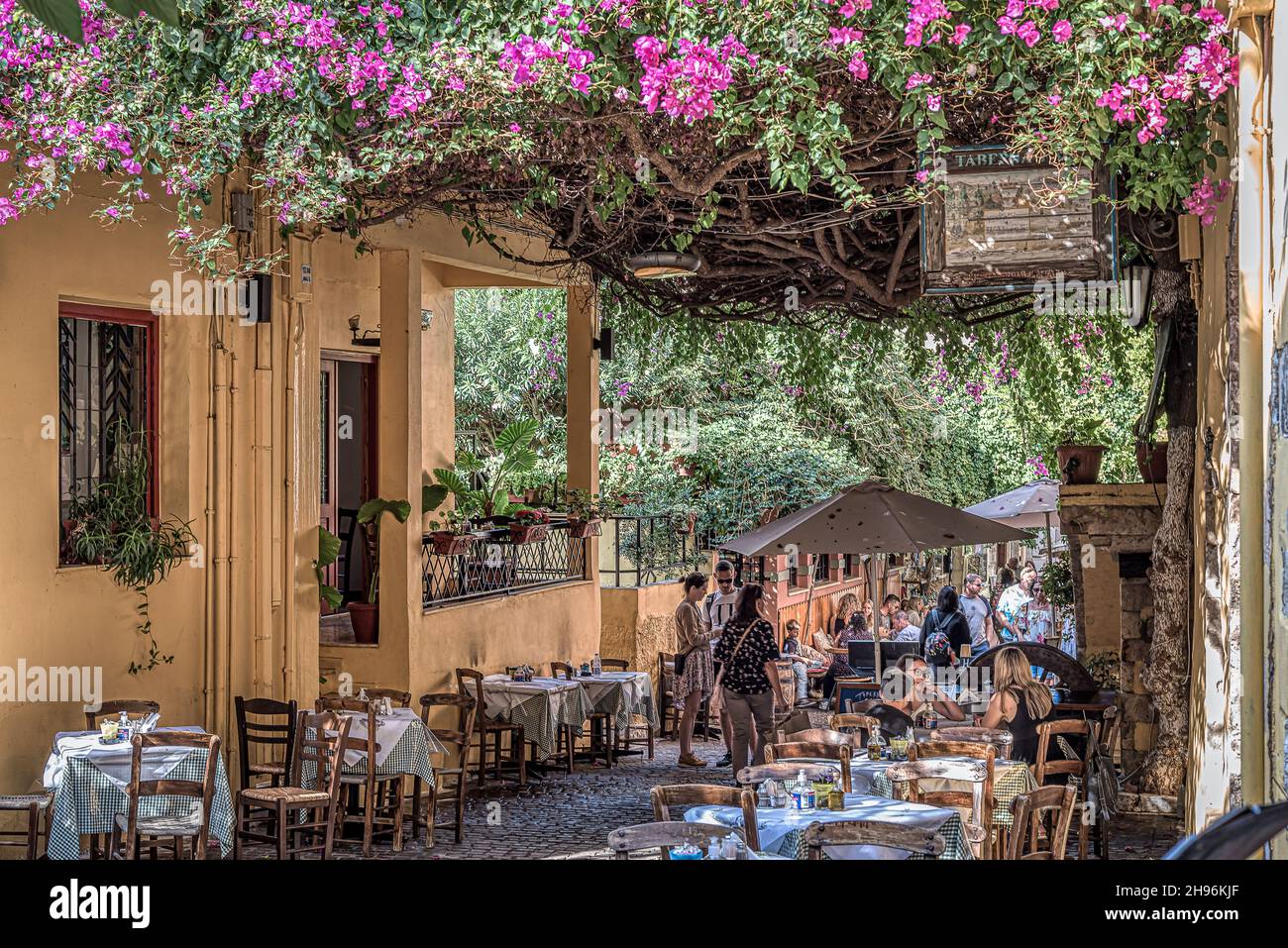 Touristen, die unter der Bougainvillea in der Altstadt von Chania, Kreta, Griechenland, zu Abend essen, 18. Oktober 2021 Stockfoto