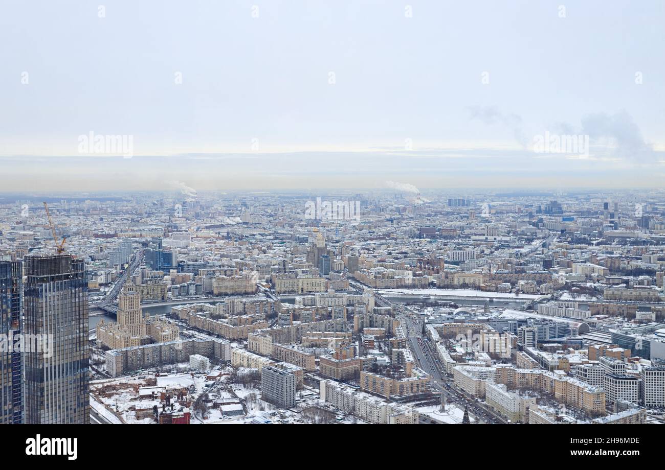 Blick von oben auf Moskau an einem Wintertag. Städtische Gebiete und Autobahnen sind mit Schnee bedeckt. Alltag der Stadt. Stockfoto