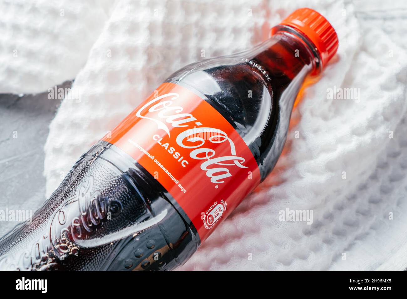 Bortset udskille Wade Klare Plastikflasche von Coca-Cola liegt auf grauer Betonoberfläche mit  weißem Handtuch. Flasche mit rotem Etikett beschriftet mit einzigartigen  erfrischenden Geschmack in Stockfotografie - Alamy