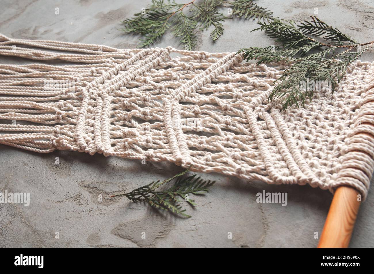 Nahaufnahme handgemachtes Makrammuster. Natürliches Dekorationskonzept im Innenraum. Einrichtung mit Baumwollkordel und Macrame Stockfoto