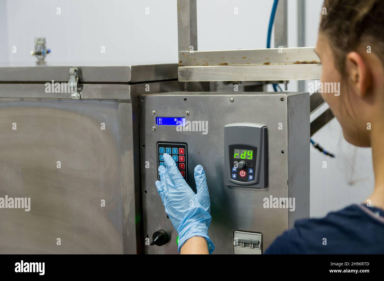 Frau, die in der Industrie arbeitet und Ausrüstung anpasst Stockfoto
