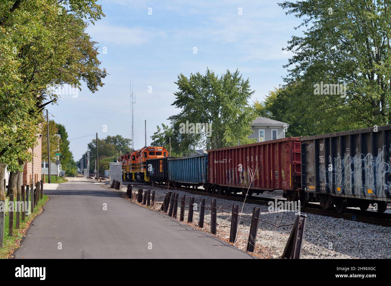 Warschau, Indiana, USA. Ein Güterzug rumpelt langsam durch die Innenstadt einer kleinen Gemeinde im Norden von Indiana. Stockfoto