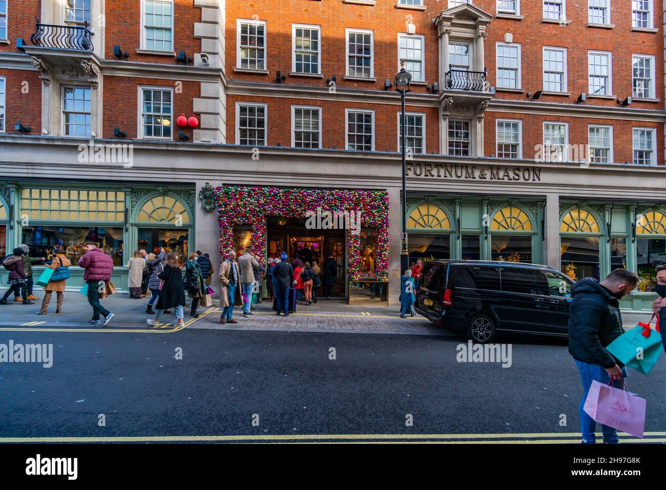 LONDON, Großbritannien - 04. DEZEMBER 2021: Shopper gehen in eines der besten Geschäfte der Welt Fortnum und Mason gegründet 1707 in Piccadilly London Stockfoto LONDON, Großbritannien - 04. DEZEMBER 2021: Shopper gehen in eines der besten Geschäfte der Welt Fortnum und Mason gegründet 1707 in Piccadilly London Stockfoto