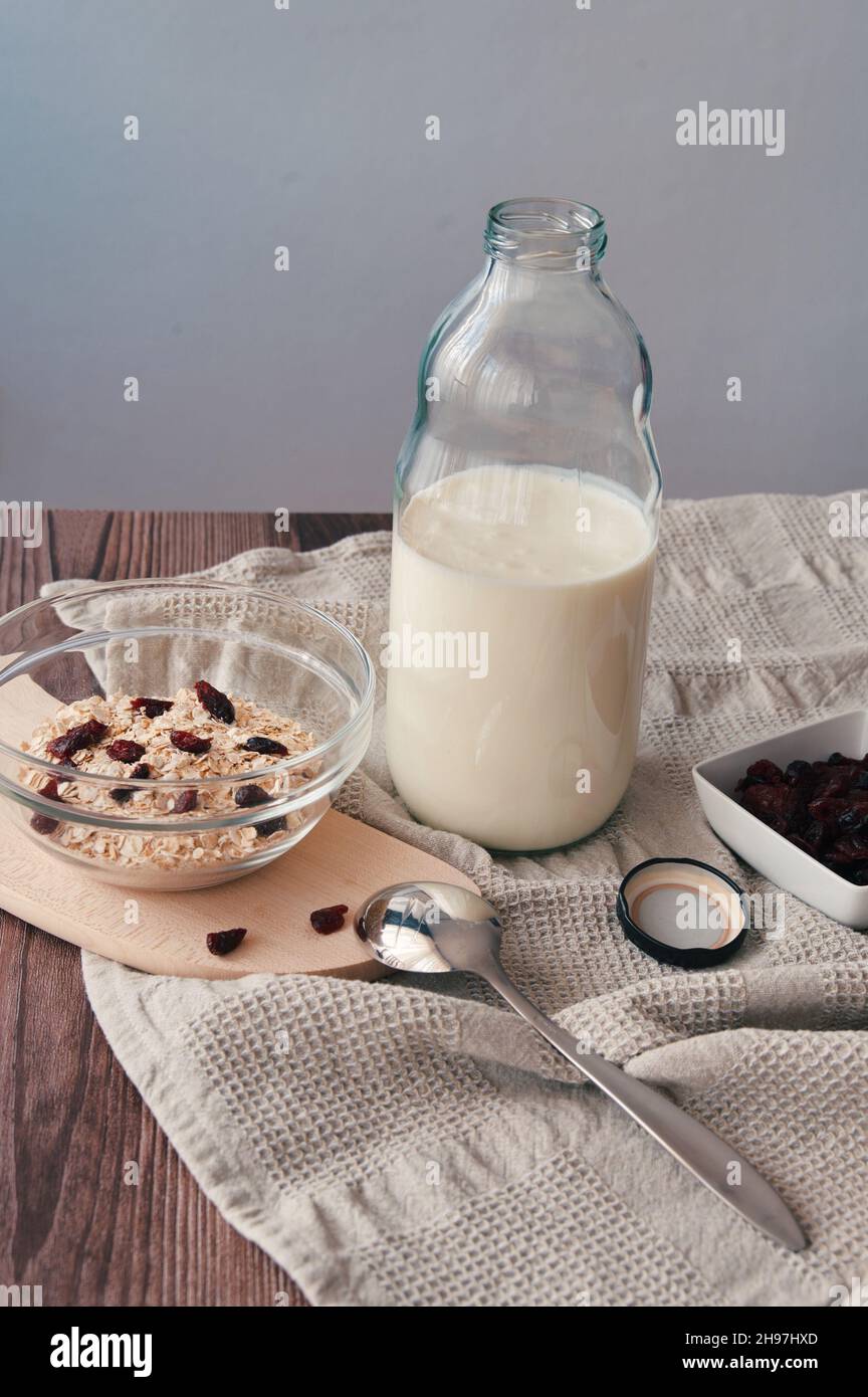 Haferflocken, Milch und Trockenobst auf dem Tisch Stockfoto