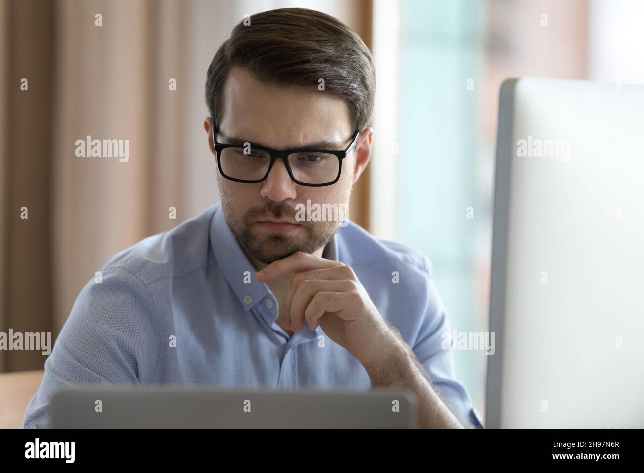 Fokussierter Business-Profi Mann in Brille, der am Projekt arbeitet Stockfoto