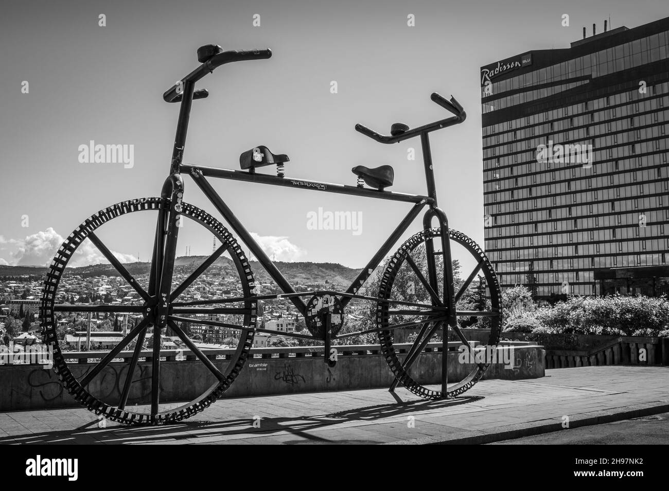 Riesiges zweiseitiges Fahrraddenkmal auf der Rustaveli Avenue. Tiflis, Georgien. Schwarz und Weiß. Stockfoto