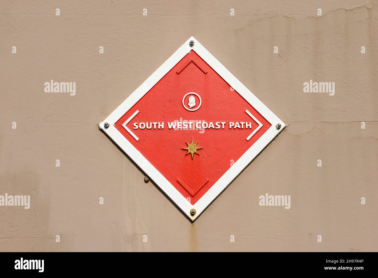 Ein Schild, das auf den South West Coast Path an einer Wand in Plymouth, Devon, Großbritannien, hinweist Stockfoto