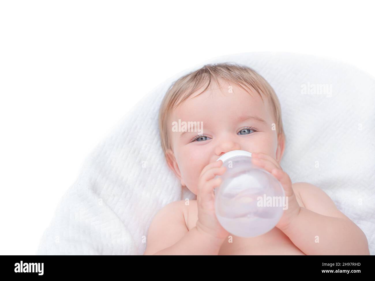 Das Baby trinkt aus einer Flasche. Kind hält Wasserflasche isolieren Stockfoto