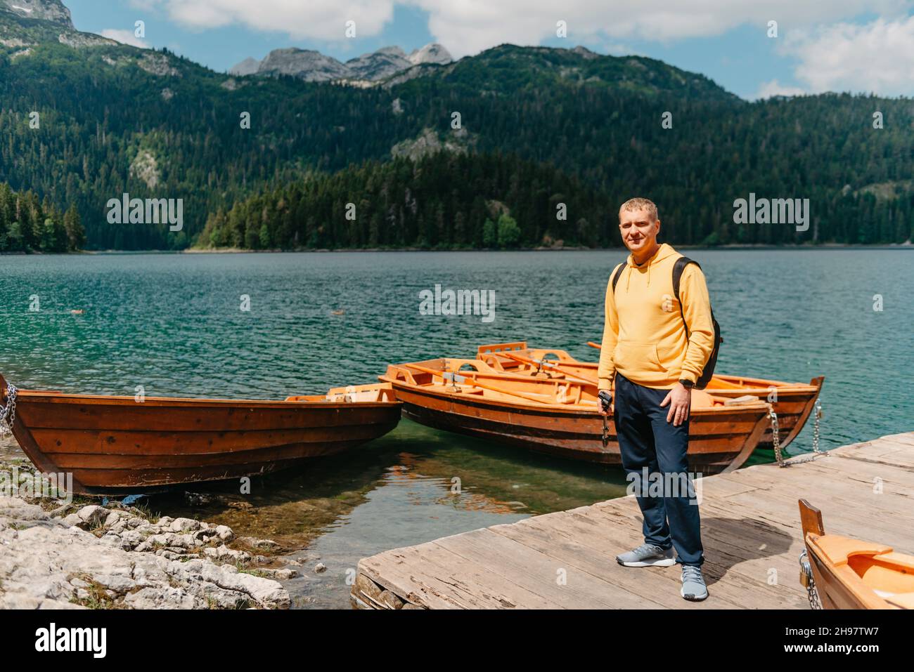 Junger Mann mit Blick auf den Schwarzen See, den Durmitor-Nationalpark, Zabljak, Montenegro. Hippster Reisender mit Blick auf den Black Lake Stockfoto