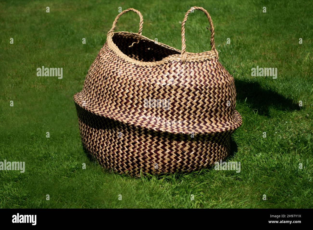 Ein gewebter Korb auf einem Rasen in der Sonne Stockfoto