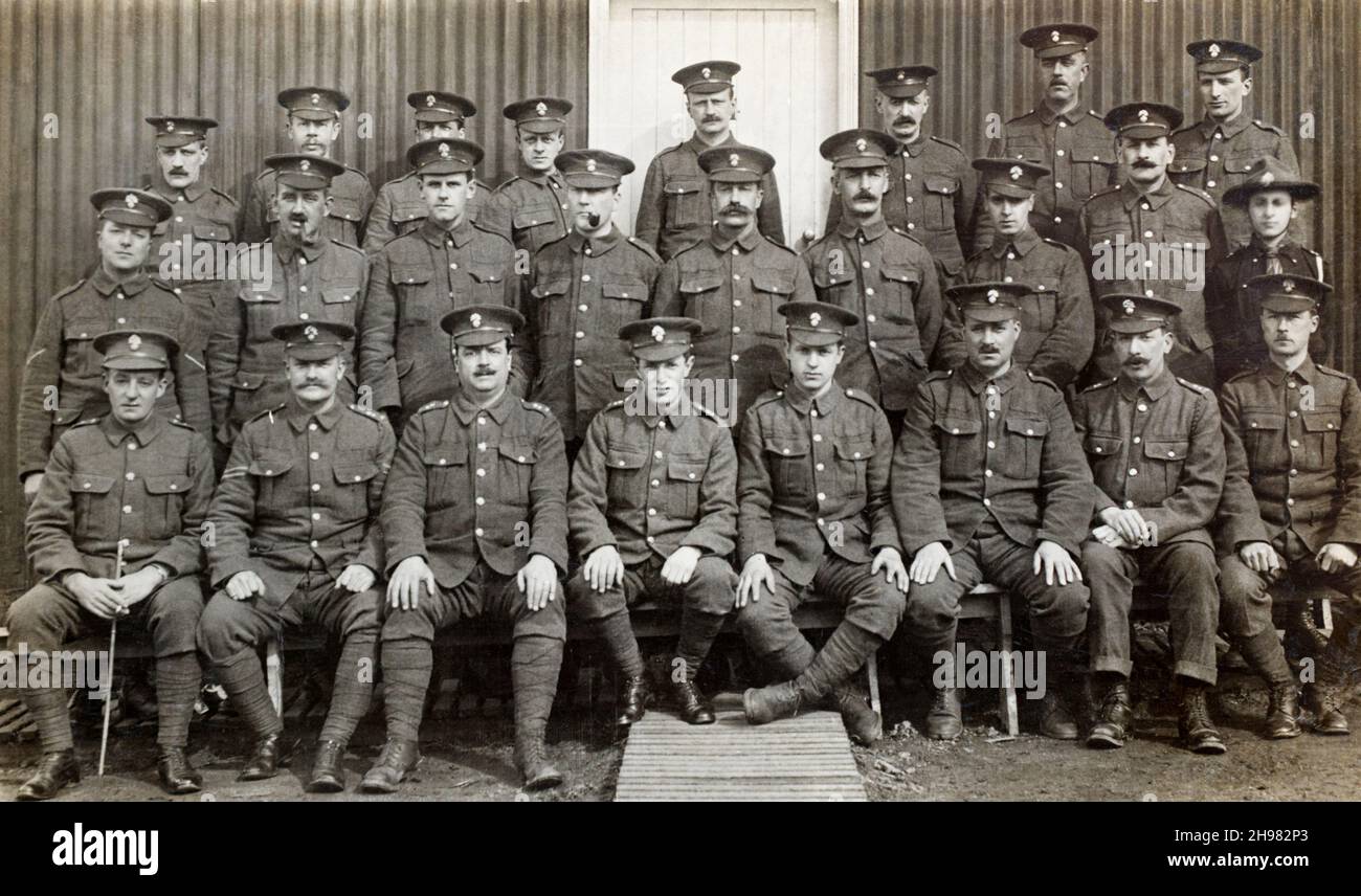 Eine Gruppe britischer Soldaten aus der Zeit des Ersten Weltkriegs in den Royal Fusiliers vor einer Barackenhütte. Ein Pfadfinder ist in der Gruppe ganz rechts. Stockfoto