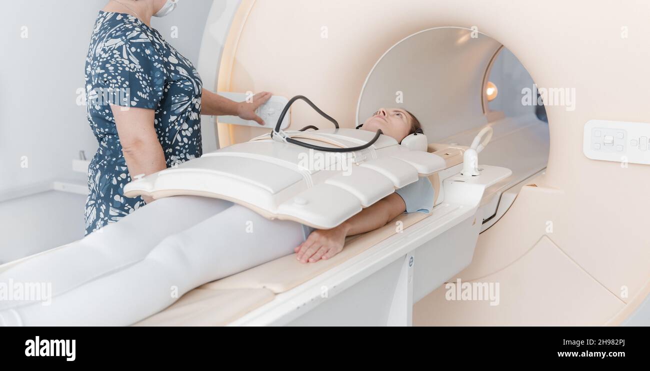 Arzt oder Krankenschwester und Patient mit Tomographie-CT oder MRI-Scan im Krankenhaus. Innenansicht der Radiographie-Abteilung. Technologisch fortschrittliche Ausrüstung in Stockfoto