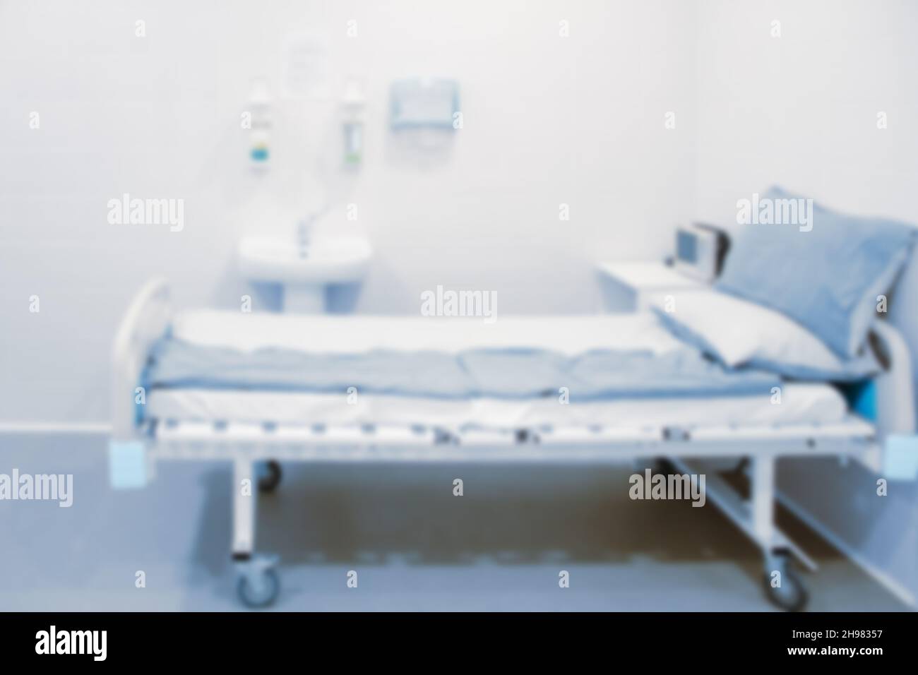 Verschwommenes Foto des Operationssaal in einem Krankenhaus. Chirurgische Ausrüstung mit Operationstisch. Medizinisches Gerät für Notfallpatienten im Blauton-Stil Stockfoto