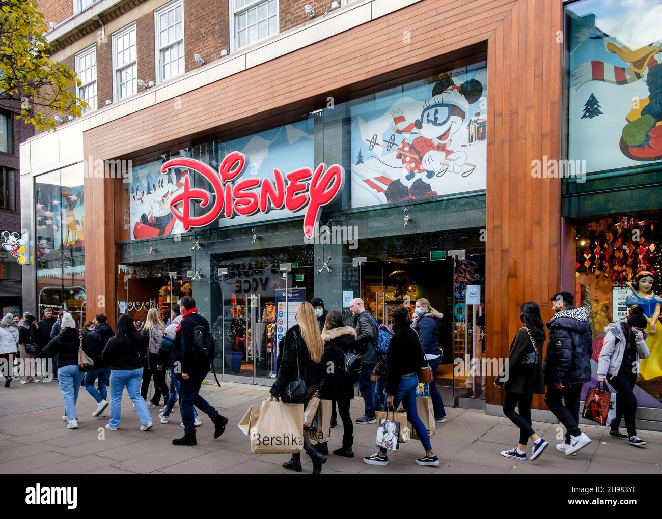 Weihnachtseinkäufer im Disney-Laden in der Londoner Oxford Street. Die britische Regierung hat Maßnahmen neu erlassen, die es zu einer rechtlichen Verpflichtung machen, Gesichtsbezüge in Geschäften und öffentlichen Verkehrsmitteln zu tragen, sofern sie nicht vom 30th. November ausgenommen sind, weil sie Bedenken wegen der Omicron-Variante von covid-19 hatte. Stockfoto