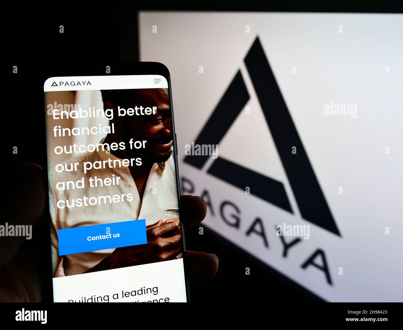 Person, die Mobiltelefon mit der Webseite des Finanztechnologieunternehmens Pagaya Investments auf dem Bildschirm mit Logo hält. Konzentrieren Sie sich auf die Mitte des Telefondisplays. Stockfoto