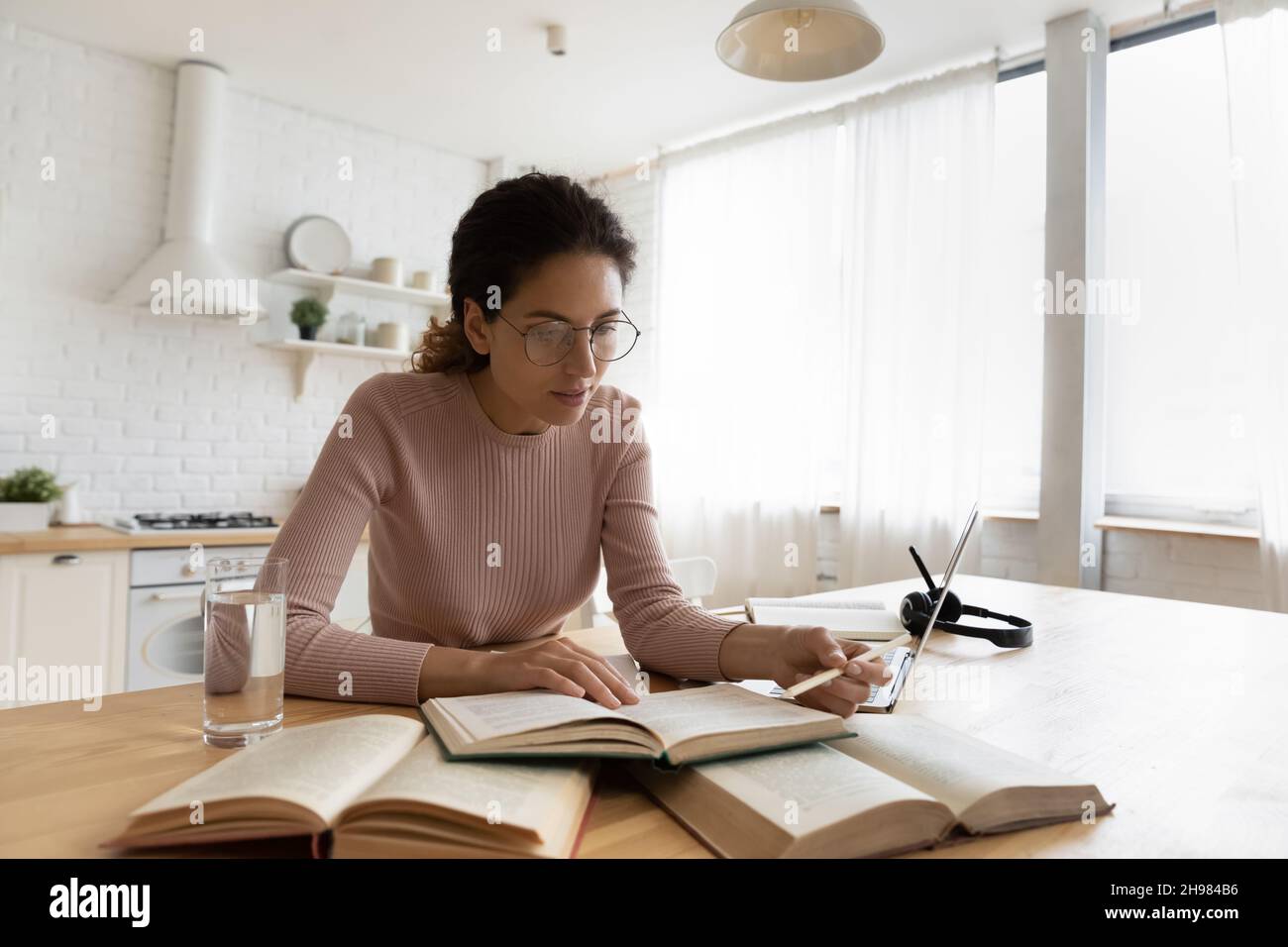 Frau in Brille, die sich auf die Prüfung vorbereitet, zu Hause studiert Stockfoto