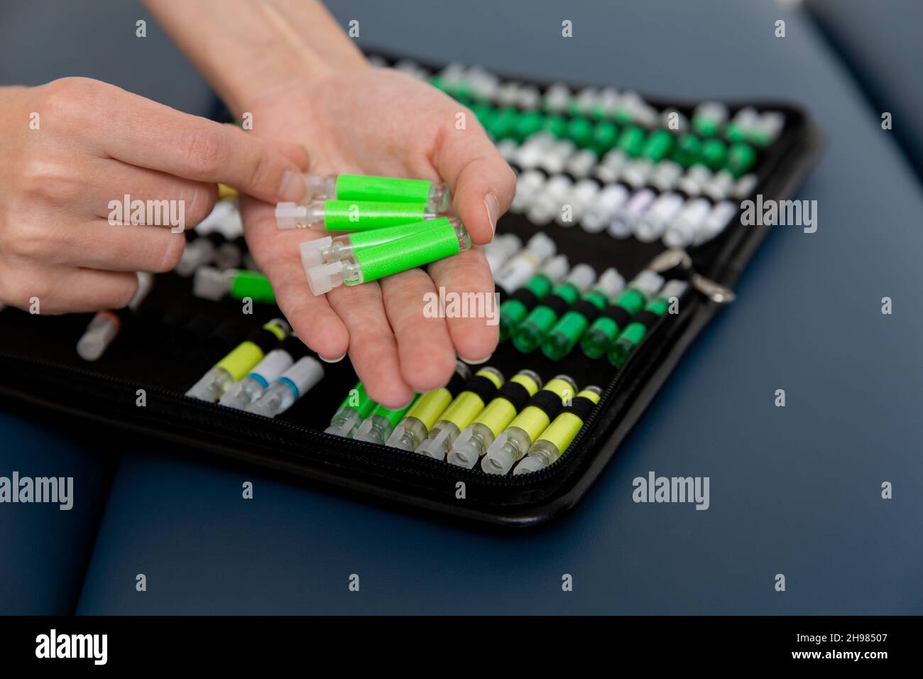 Der Arzt hält kleine Ampullen in den Händen. Nahaufnahme einer kleinen Ampulle mit einem Impfstoff in der Hand des Arztes. Reagenzglas für Allergietest halten. Allergietests Stockfoto