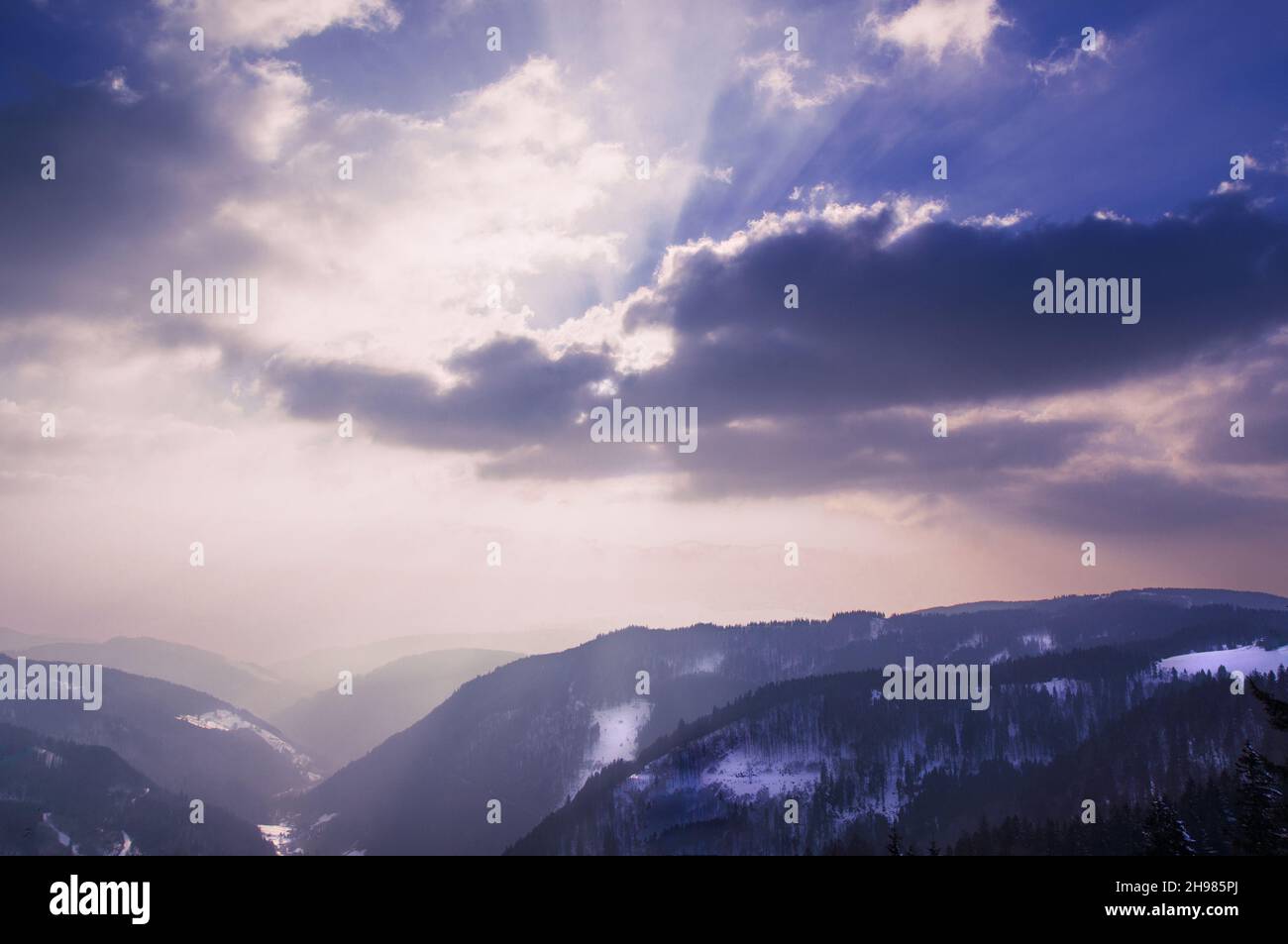Die Hügel des Schwarzwaldes verschwinden im Licht des Sonnenuntergangs im Dunst. Stockfoto