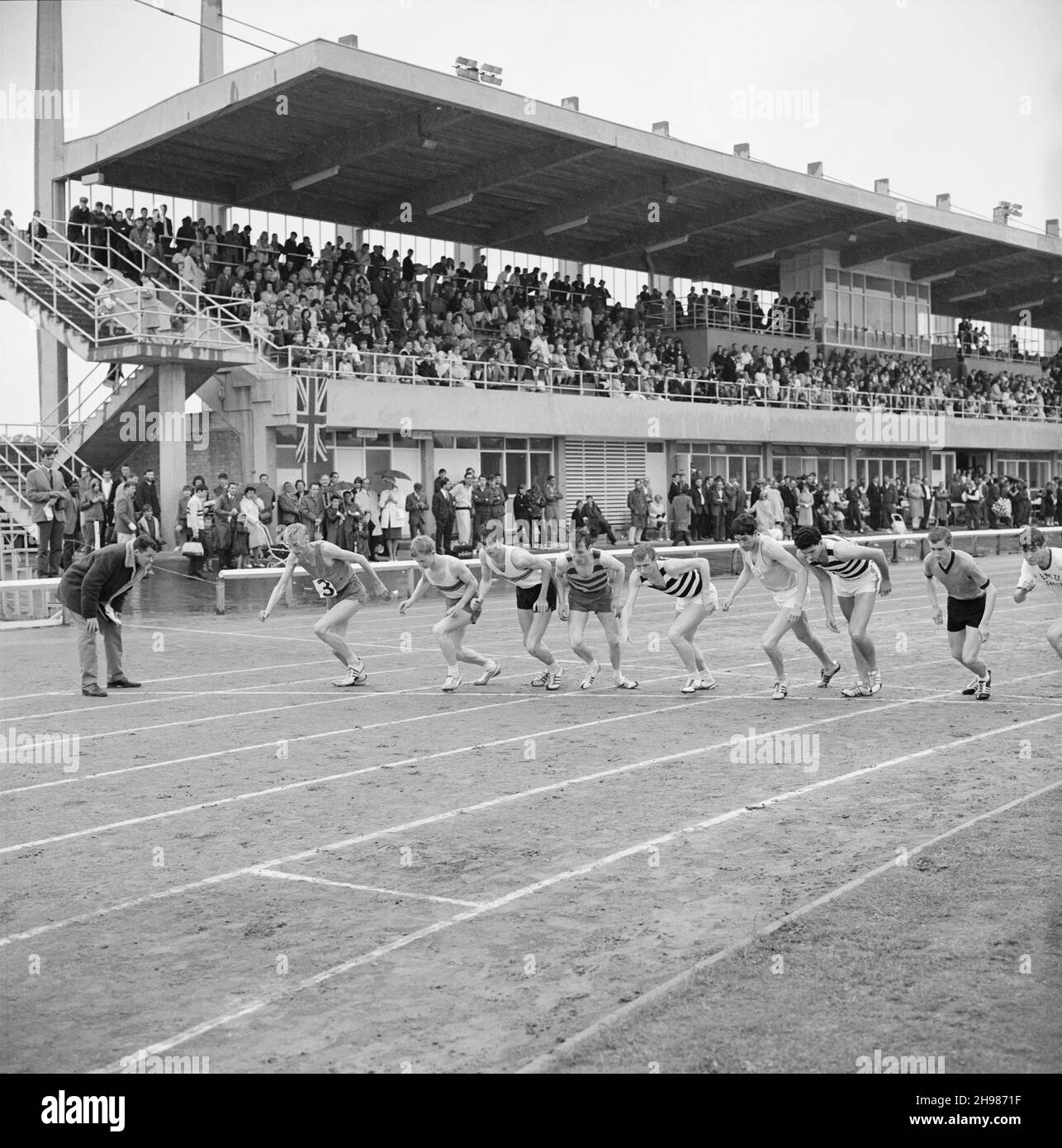 Copthall Stadium, Hendon, Barnett, London, 25/06/1966. Die Männer waren beim jährlichen Laing Sports Day, der im Copthall Stadium stattfindet, an der Startlinie eines Streckenevents mit Zuschauern auf Ständen im Hintergrund. Im Jahr 1966 fand am 25th. Juni der jährliche Laing Employees' Sports Day im Copthall Stadium in Hendon statt. Es war das erste Mal, dass die Veranstaltung dort stattfand, nachdem zuvor der Laing Sports Ground in Elstree stattgefunden hatte. Eine Reihe von Veranstaltungen umfasste Leichtathletik und einen Fußballwettbewerb, und die Teilnehmer reisten von den regionalen Büros und Standorten des Unternehmens, darunter aus Schottland und Carlisle. Da war al Stockfoto