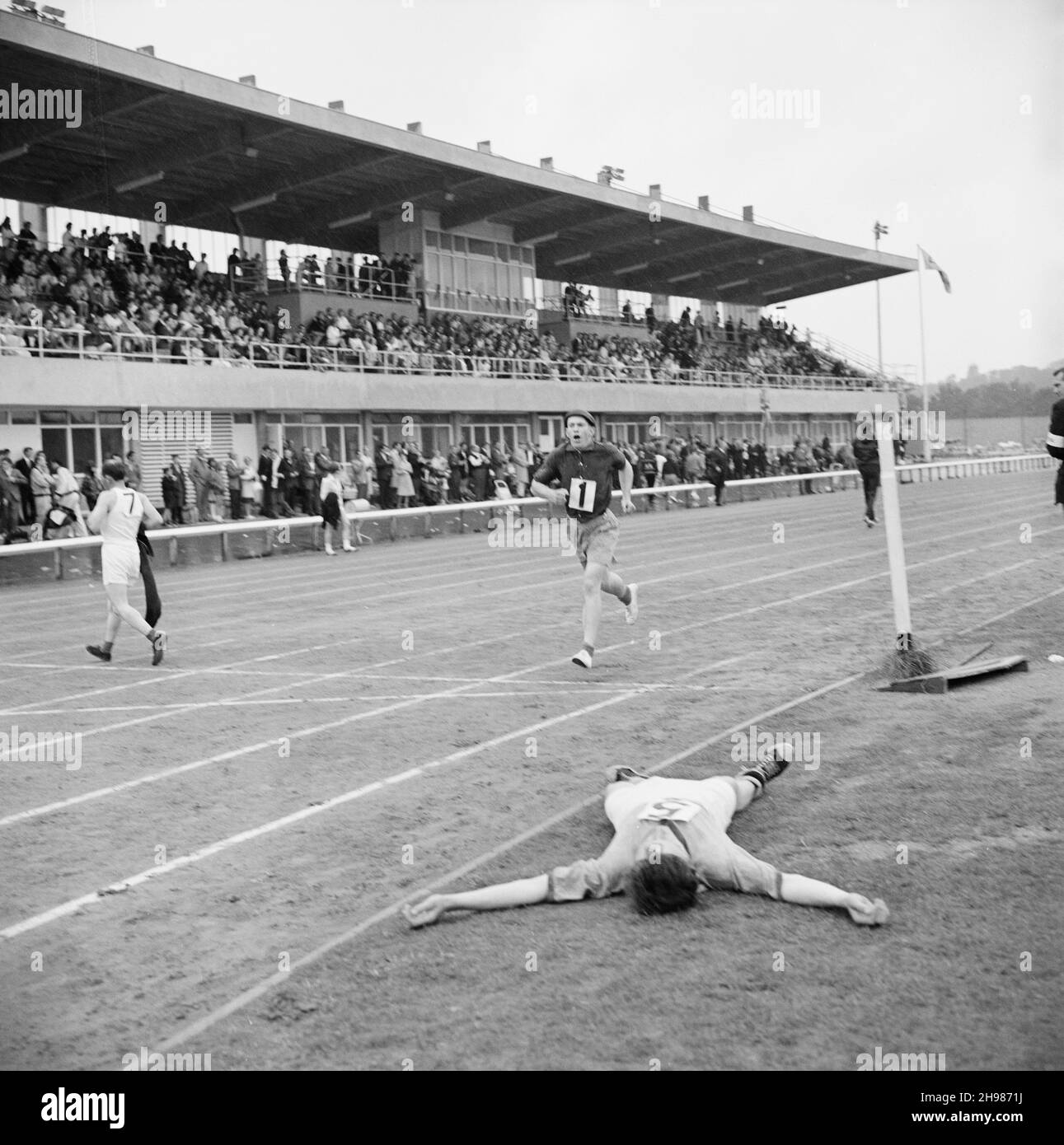 Copthall Stadium, Hendon, Barnett, London, 25/06/1966. Ein Teilnehmer brach am Boden zusammen, nachdem er ein Rennen beendet hatte, das während des jährlichen Laing Sports Day im Copthall Stadium stattfand. Im Jahr 1966 fand am 25th. Juni der jährliche Laing Employees' Sports Day im Copthall Stadium in Hendon statt. Es war das erste Mal, dass die Veranstaltung dort stattfand, nachdem zuvor der Laing Sports Ground in Elstree stattgefunden hatte. Eine Reihe von Veranstaltungen umfasste Leichtathletik und einen Fußballwettbewerb, und die Teilnehmer reisten von den regionalen Büros und Standorten des Unternehmens, darunter aus Schottland und Carlisle. Es gab auch einen Jahrmarkt, Marchi Stockfoto