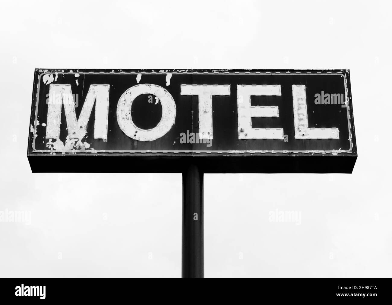 Schwarz-Weiß-Foto eines großen heruntergekommenen und abblätternden Motelschildes im Süden Stockfoto