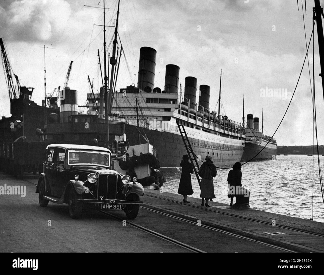 1935 Daimler Light 15 mit dem Liner Aquitania an den Docks von Southampton, Hampshire. Stockfoto