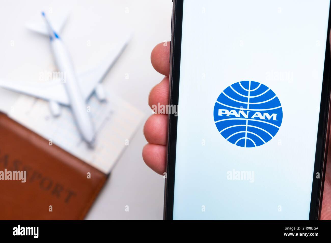 Pan am Airline-Logo auf dem Handybildschirm mit einem Flugzeug, einem Reisepass und einer Bordkarte im Hintergrund. Das Konzept der mobilen Anwendung der Fluggesellschaften. November 2021, San Francisco, USA Stockfoto