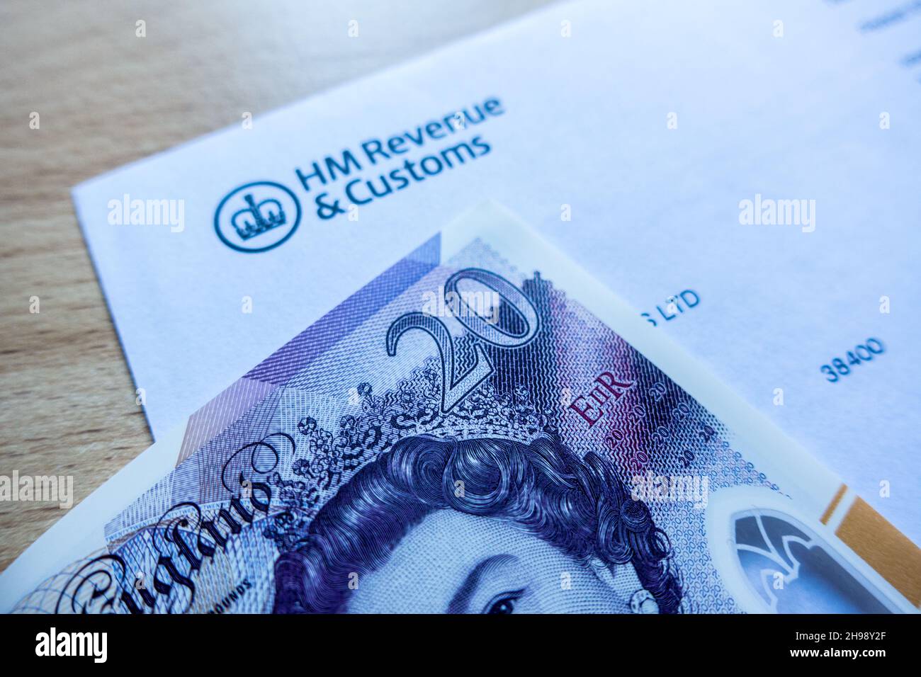 HM Revenue and Customs Logo auf einem Brief mit einer 20-Pfund-Note auf dem Tisch gedruckt Stockfoto