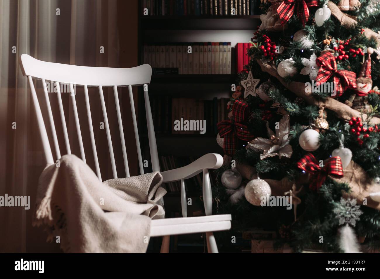 Retro-weißer Schaukelstuhl aus Holz neben einem Weihnachtsbaum Stockfoto