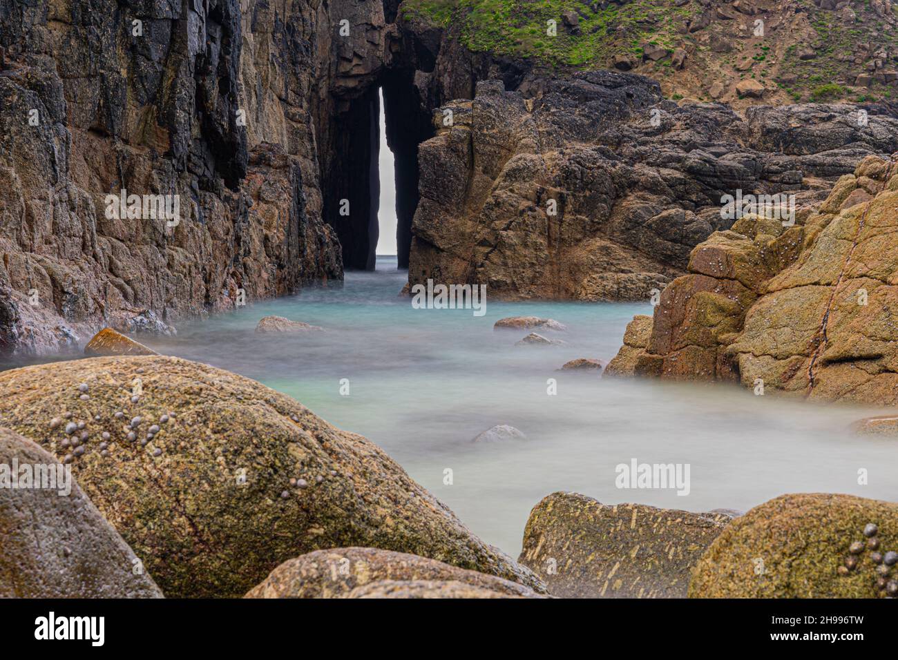 Der Felsenpool und das Lied der Meereshöhle bei Nanjizal in Cornwall Stockfoto