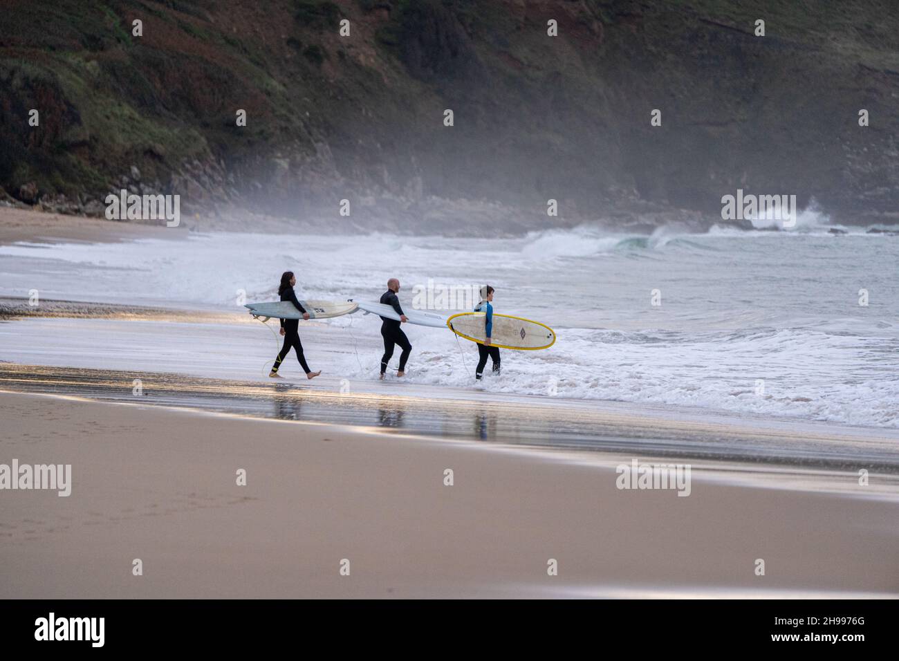 Am beliebten Praa Sands Strand an der Südküste von Cornwall gehen drei Surfer zum Surfen ins Wasser. Stockfoto Am beliebten Praa Sands Strand an der Südküste von Cornwall gehen drei Surfer zum Surfen ins Wasser. Stockfoto
