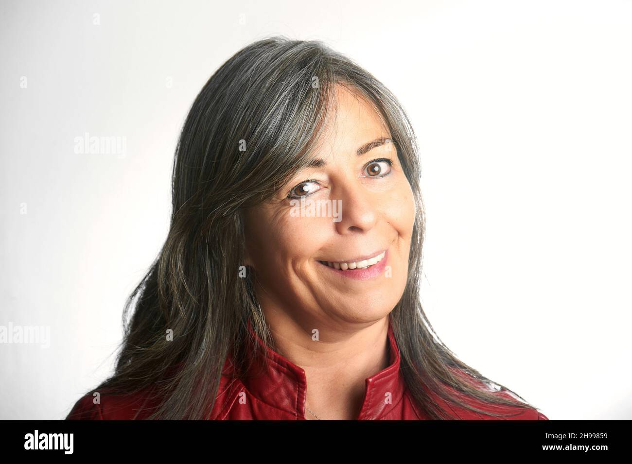 Nahaufnahme eines schönen lächelnden älteren Frau mit grauen Haaren und einer roten Jacke. Stockfoto