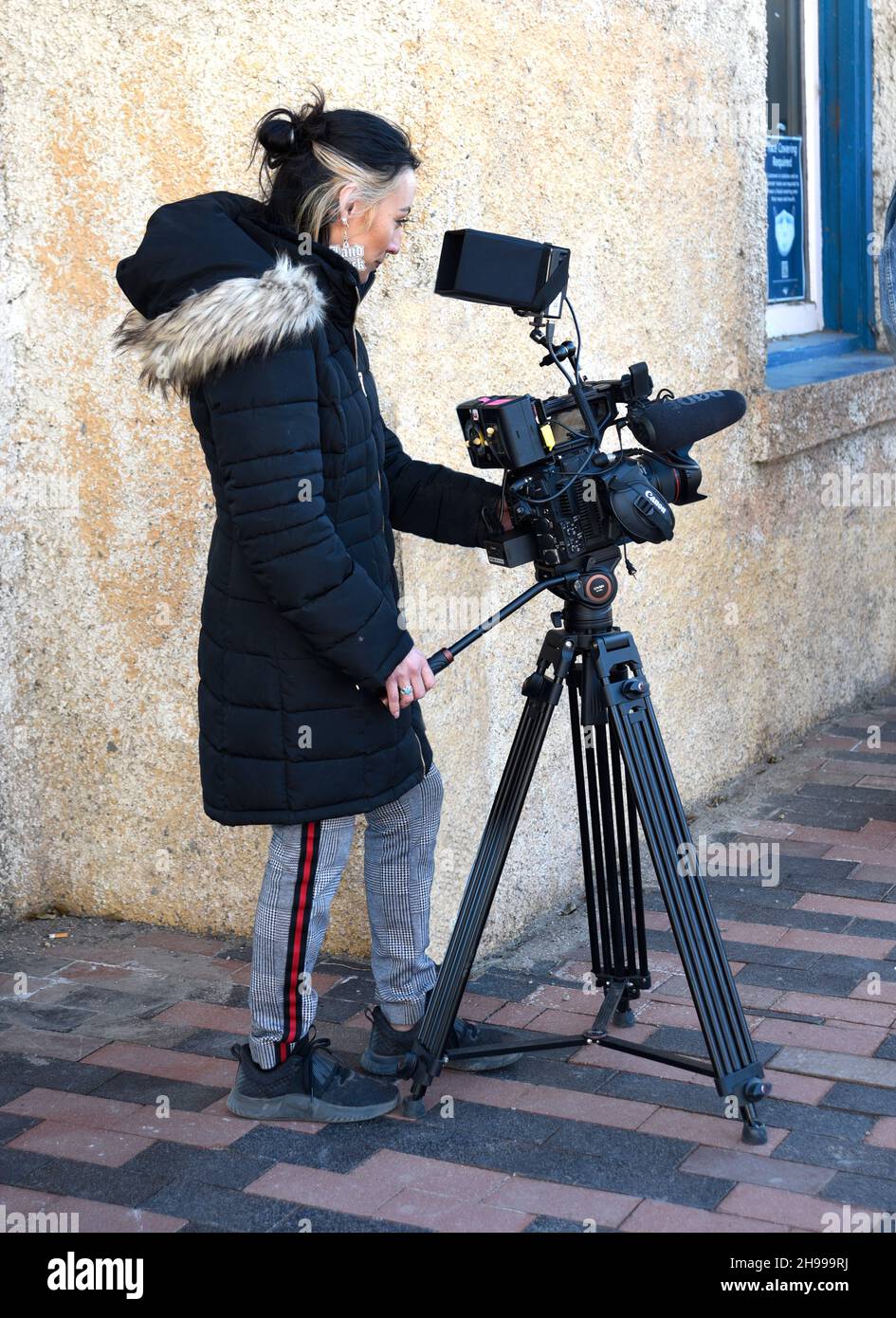 Ein junger Filmemacher betreibt eine Canon Videokamera, während er am historischen Bahnhof Lamy in Lamy, New Mexico, eine Dokumentation dreht. Stockfoto