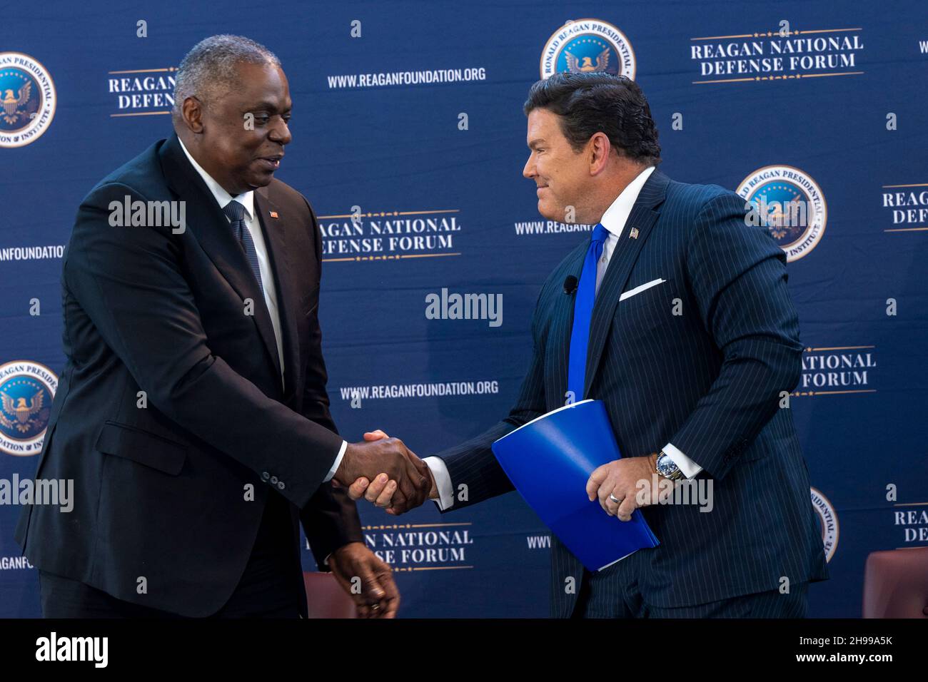 Simi Valley, Usa. 04th Dez 2021. US-Verteidigungsminister Lloyd J. Austin III begrüßt den Vertreter von Fox News Brett Baier während des Reagan National Defense Forum 2021 in der Ronald Reagan Presidential Library am 4. Dezember 2021 in Simi Valley, Kalifornien. Quelle: Chad McNeeley/DOD/Alamy Live News Stockfoto