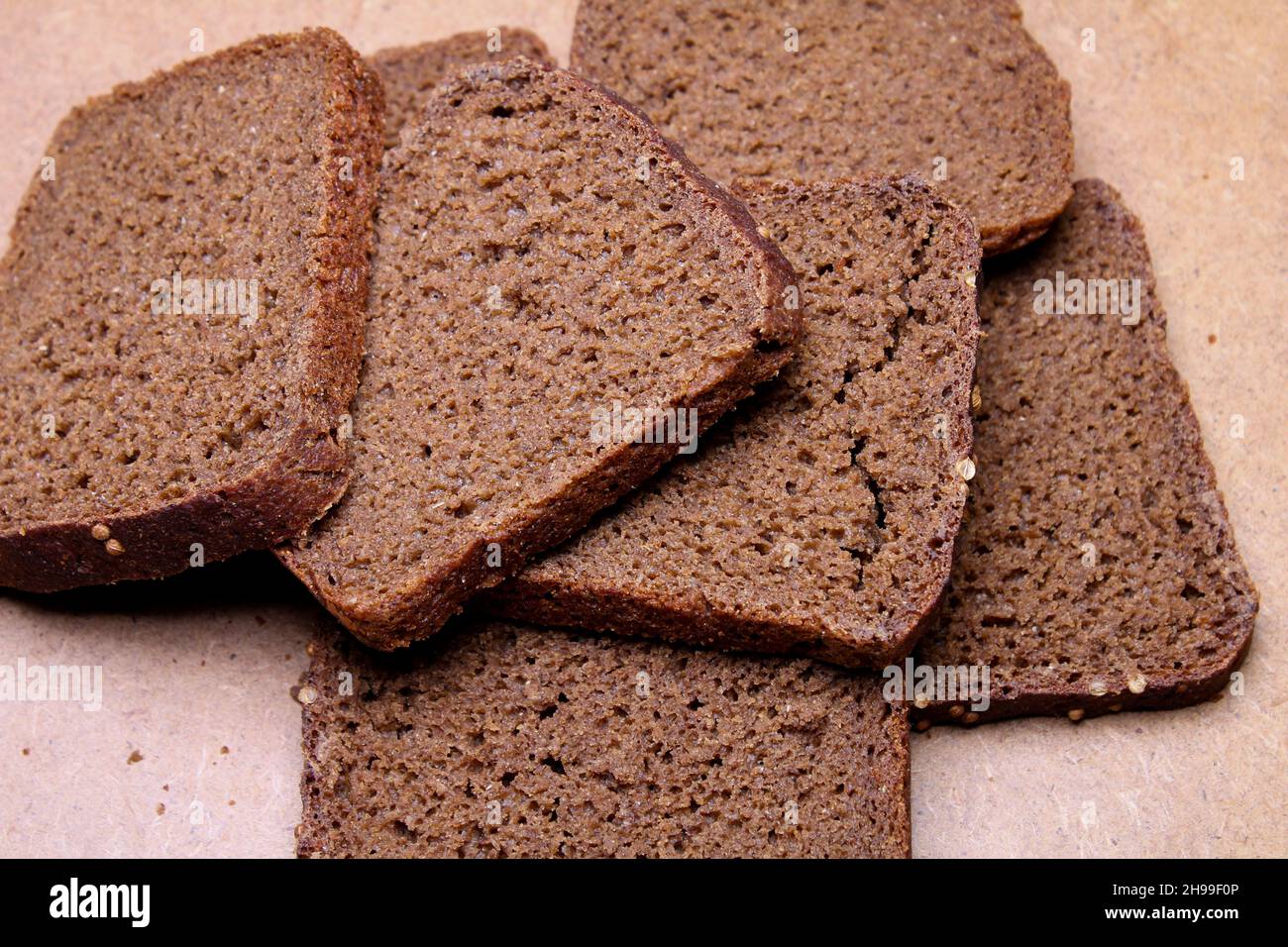 Schwarzes Brot, in Scheiben geschnitten auf einem Holzständer Stockfoto