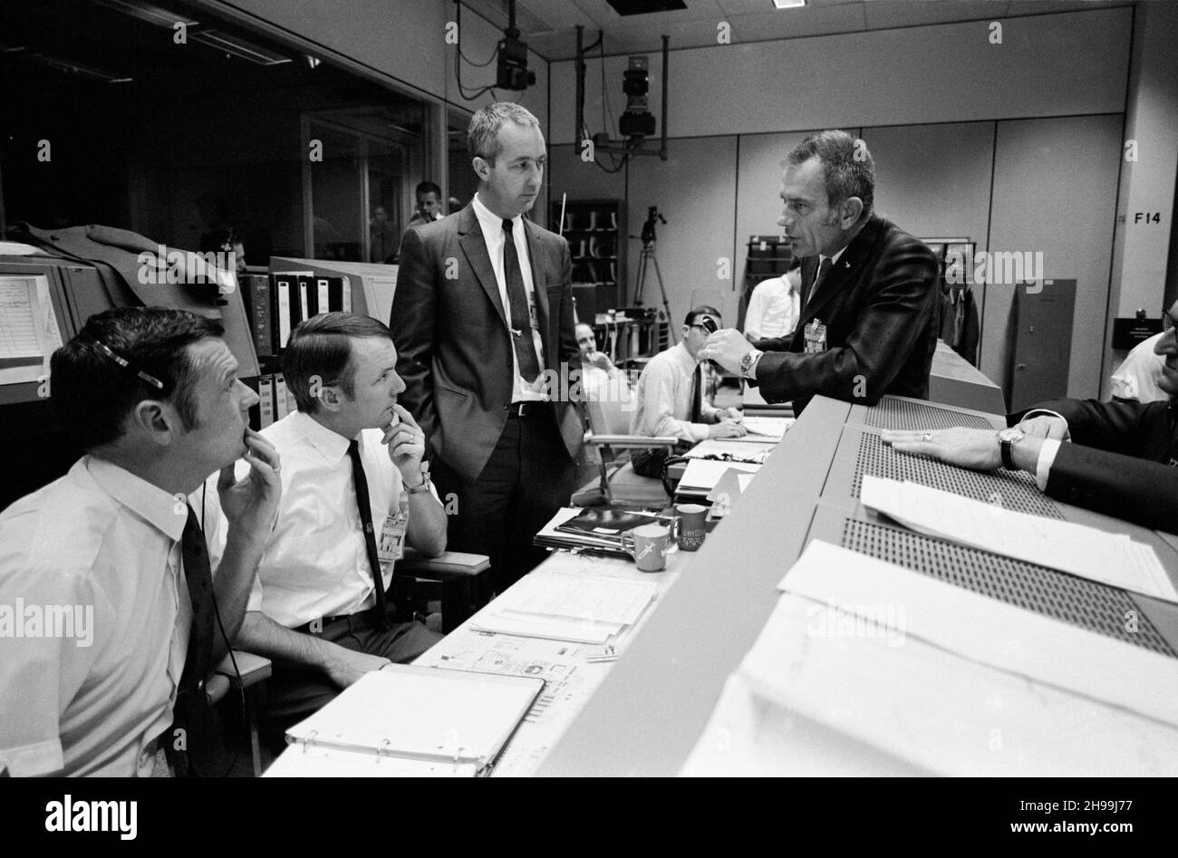 Diskussion im Mission Operations Control Room (MOCR), der sich mit den Apollo 13-Besatzungsleuten während ihres letzten Tages im Weltall beschäftigt. Von links nach rechts sind Glynn S. Lunney, Flugdirektor von Shift 4; Gerald D. Griffin, Flugdirektor von Shift 2; Astronaut James A. McDivitt, Manager, Apollo Spacecraft Program, MSC; Dr. Donald K. Slayton, Direktor von Flight Crew Operations, MSC; und Dr. Willard R. Hawkins, M.D., Flugchirurg von Shift 1. Stockfoto