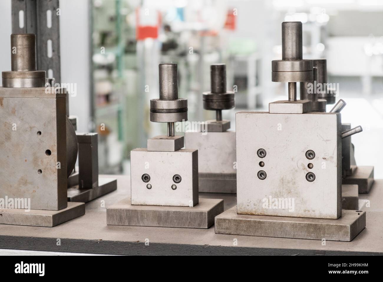 Werkzeugmaschinen mit glänzenden Metallzylindern in hell erleuchteter Werkstatt der modernen Fertigungsanlage extreme Nahsicht Stockfoto