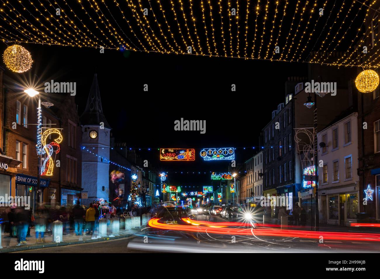 Dunbar, East Lothian, Schottland, Großbritannien, 5th. Dezember 2021. Weihnachtslichter schalten ein: Die festlichen Lichter auf der High Street sind heute Abend eingeschaltet. Im Bild: Die Weihnachtslichter sind auf der anderen Straßenseite aufgehangen Stockfoto