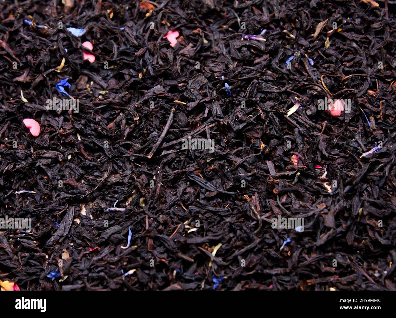 Schwarzblatt-Tee mit Blütenblättern aus der Nähe, trinken Stockfoto