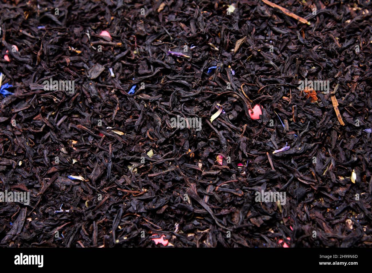 Schwarzblatt-Tee mit Blütenblättern aus der Nähe, trinken Stockfoto