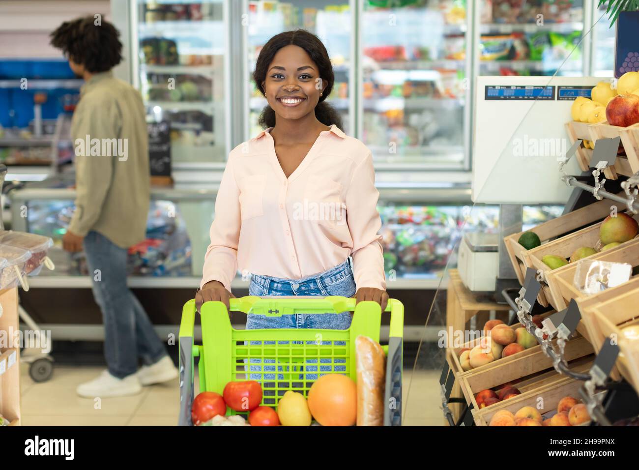 Schwarze Frau Einkaufen Lebensmittel Posiert Mit Einkaufswagen Im Supermarkt Stockfoto