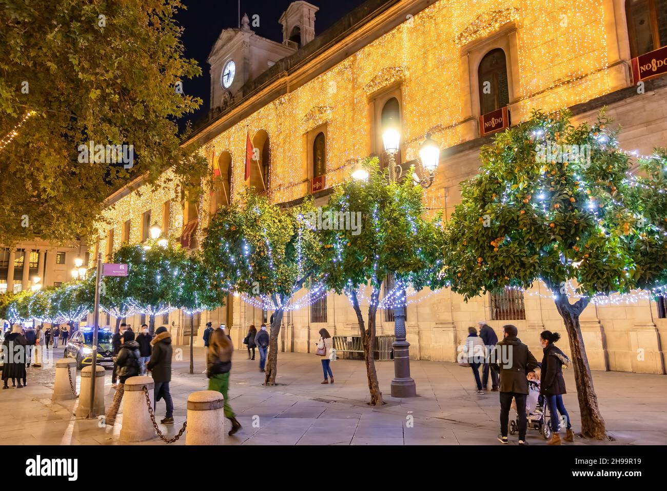 Sevilla, Spanien - 22,2020. Dezember: Nicht identifizierte Personen, die zur weihnachtszeit durch das Rathaus von Sevilla laufen. Personen, die eine schützende Gesichtsmaske tragen Stockfoto